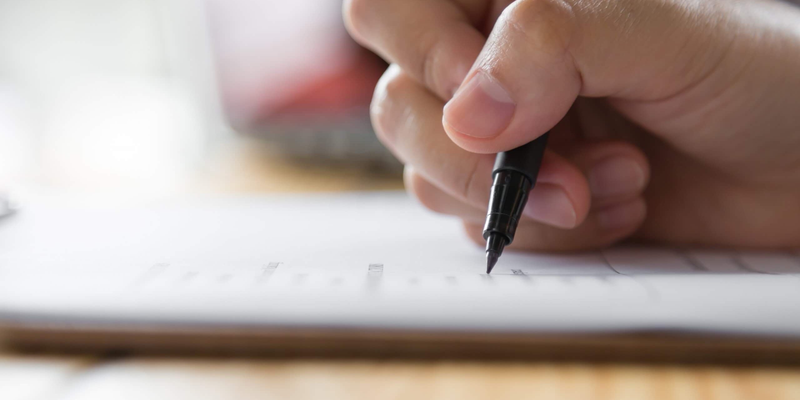 Hand with pen over application form info-APTIS